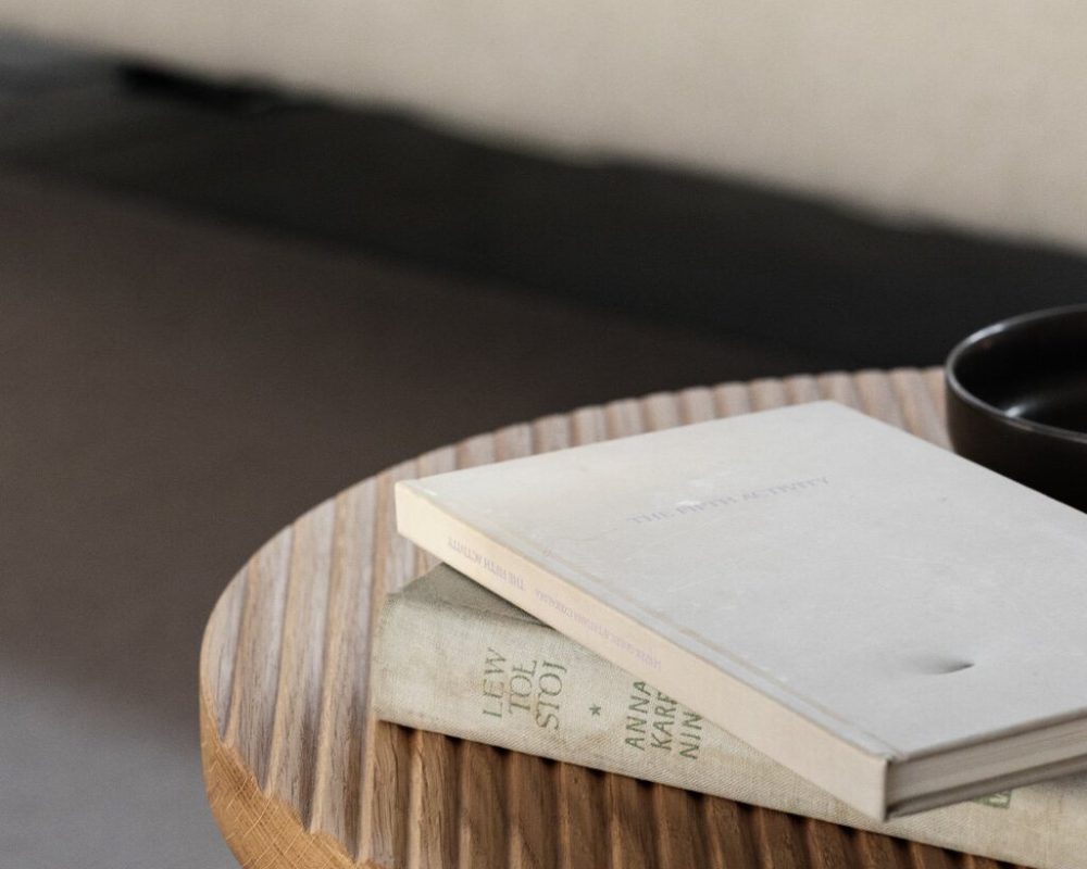 kaboompics_wooden-fluted-table-books-light-beige-sofa-oak-boucle-25042